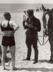Мужчину на пляже штрафуют за неподходящую одежду. Нидерланды, 1933 год