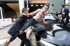 One Of The Femen protesters Is pulled from The bonnet Of The Tunisian Prime Ministers Car