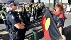 Police and a Black Lives Matter protestor are seen during a protest outside the Roma Street Magistrates Court in Brisbane.jpeg