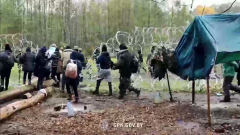 Мигранты прорывают заграждения из колючей проволоки.png